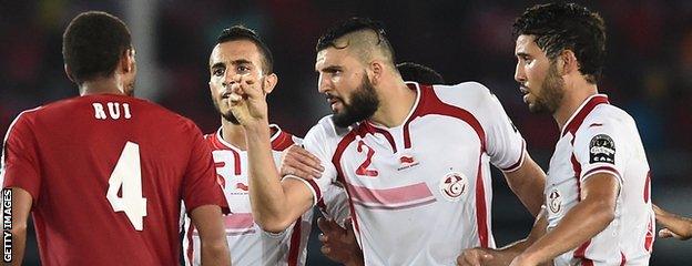 Tunisian players surround Equatorial Guinea defender Rui