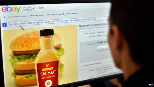 Photo illustration of a woman in Sydney looking at a webpage of eBay offering bids for fast-food giant McDonald's Big Mac special sauce.