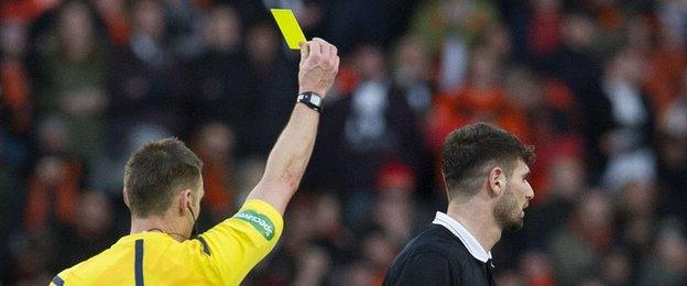 Dundee United forward Nadir Ciftci is shown a yellow card