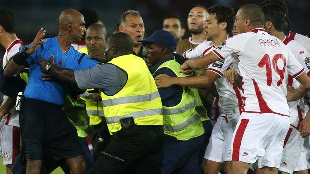 Referee Rajindraparsad Seechurn is confronted by Tunisia players after the game against Equatorial Guinea