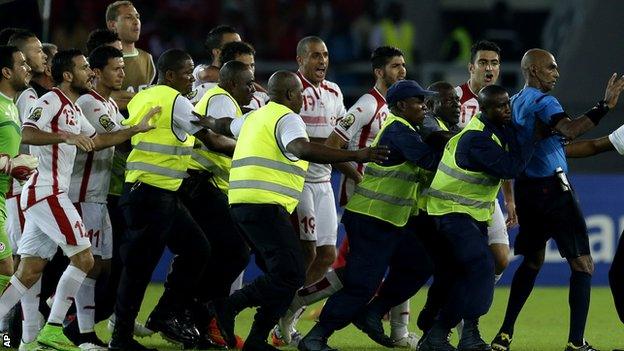 Referee Rajindraparsad Seechurn is confronted by Tunisia players after the game against Equatorial Guinea