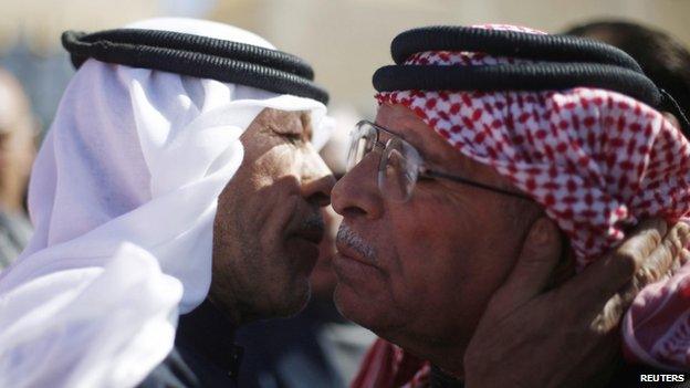 Saif al-Kasasbeh (right), father of Jordanian pilot Muath al-Kasasbeh, greets a mourner who turned up at the headquarters of the family's clan in the city of Karak (04 February 2015)