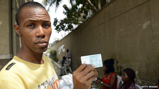 A voter shows his Permanent Voter's Card (PVC) after receiving it from officials of the Independent Electoral Commission in Lagos