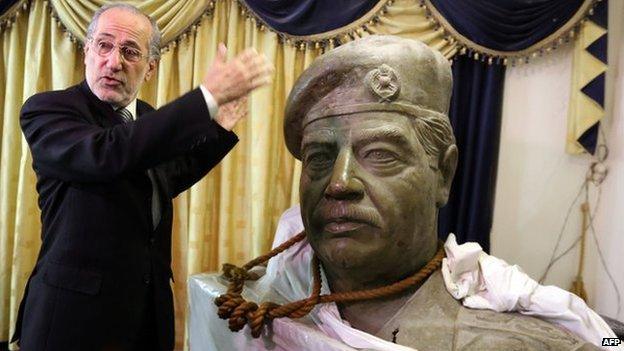 Mowaffak al-Rubaie with a statue of Saddam Hussein and the rope around its neck