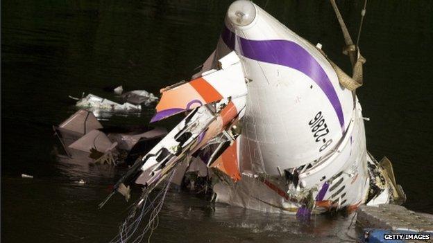 Rescuers lift the wreckage of the TransAsia ATR 72-600 out of the Keelung river at New Taipei City