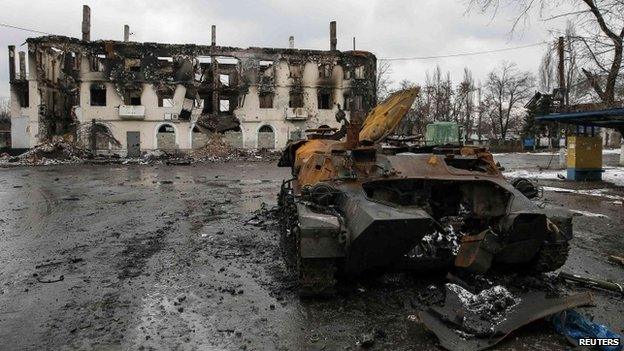 An armoured vehicle and a building, damaged during battles between Ukrainian troops and rebels in Vuhlehirsk, Donetsk region, 4 February 2015
