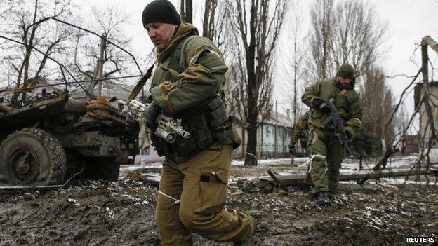 Members of the armed forces of the separatist self-proclaimed Donetsk People's Republic walk in Vuhlehirsk, 4 Feb 2015