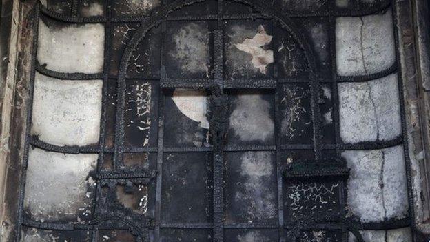 A burnt crucifix stands at the altar of St. Sebastian"s Church after a fire destroyed the church on Monday, in New Delhi, India, Tuesday, Dec. 2, 2014.