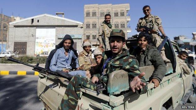 Houthi fighters sit on a patrol truck securing the vicinity of a gathering for followers of the Houthi movement in Sanaa