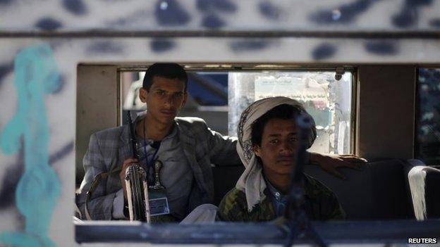 Houthi fighters sit in a vehicle as they secure the vicinity of a Houthi gathering in Sanaa