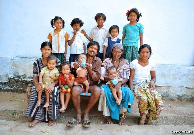 Vadthya Sukhya and Vadthya Achi pose with their eleven children in front of their home in Nalgonda District, some 150 kilometers from Hyderabad on October 21, 2011