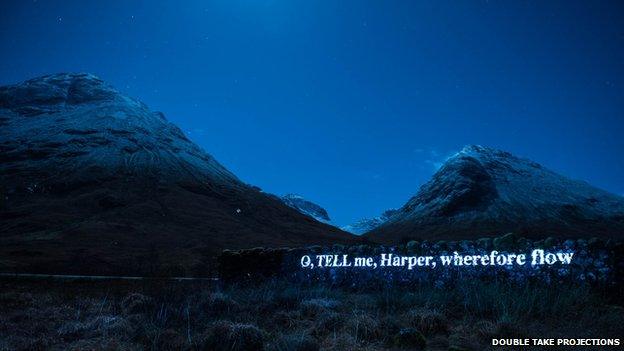 Words of poem beamed on to a dyke in Glencoe