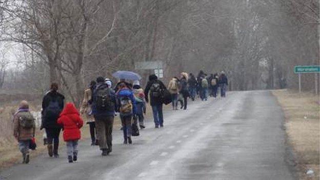 Migrants walk along the road in Asotthalom in Hungary