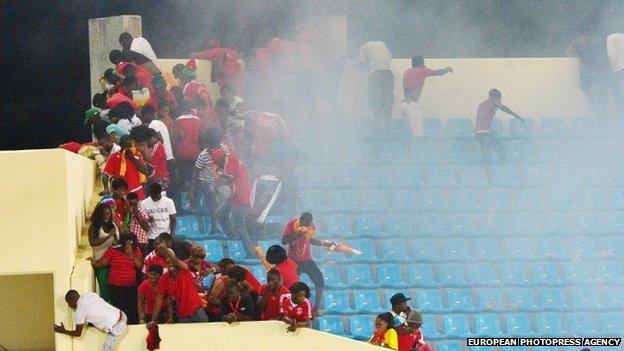 Fans flee from tear gas as violence interrupts the African Cup of Nations semi-final