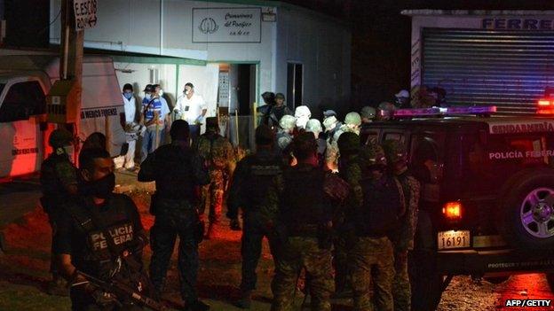 Members of the forensic medical service and soldiers stand outside a private crematorium where 61 bodies were found on 6 February 2015 in Acapulco, Mexico.