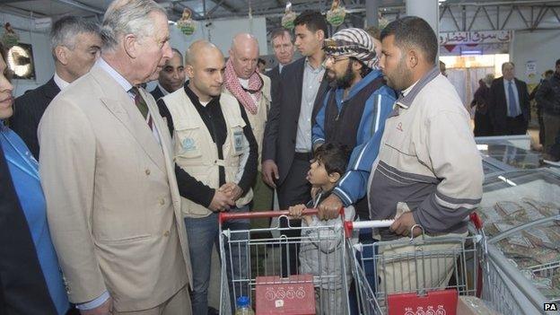 Prince Charles chats to shoppers while touring a supermarket at the Za'atri refugee camp in Jordan