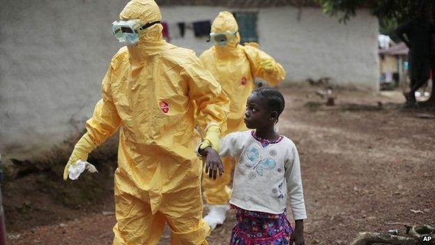 Young girl is taken to an ambulance by men in protection suits after showing signs of Ebola