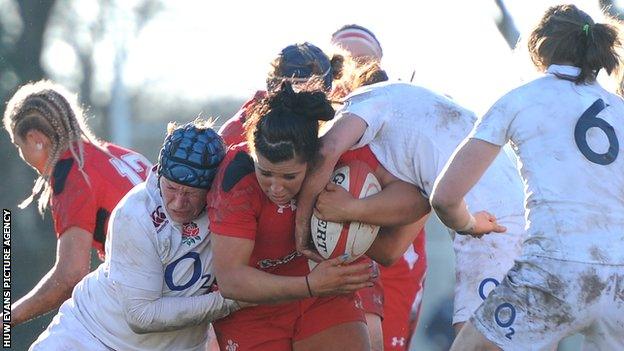 Shona Powell-Hughes of Wales is tacked by Laura Keates and Rowena Burnfield