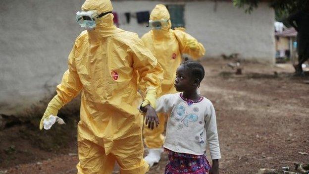 Young girl is taken to an ambulance by men in protection suits after showing signs of Ebola