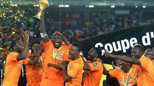 Yaya Toure celebrates and holds the trophy with his Ivory Coast team-mates