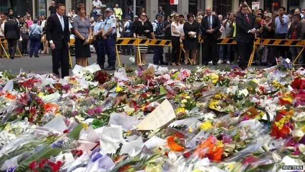 Australian Prime Minister Tony Abbott and his wife Margie stand after placing floral tributes among thousands of others near the Lindt cafe in Sydney (16 December 2014)