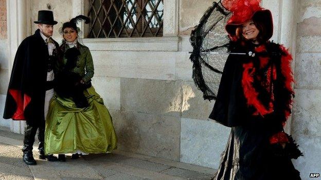 Costumed revellers pose at St Mark"s square (Piazza San marco) during the Venice Carnival on February 8, 2015 in Venice