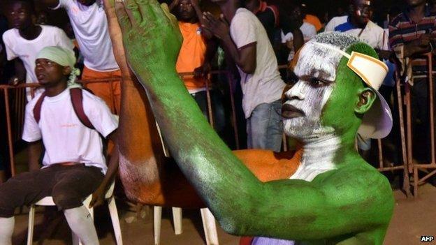 A fan painted in Ivory Coast's national colours cheers on the team in Abidjan