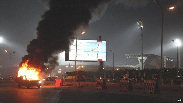 A pickup truck bursts into flames as a riot breaks out outside of a soccer match between Egyptian Premier League clubs Zamalek and ENPPI at Air Defense Stadium in a suburb east of Cairo