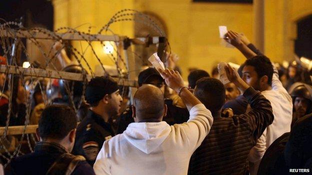 Policemen and soccer fans argue as fans attempt to enter a stadium to watch a match, on the outskirts of Cairo February 8, 2015