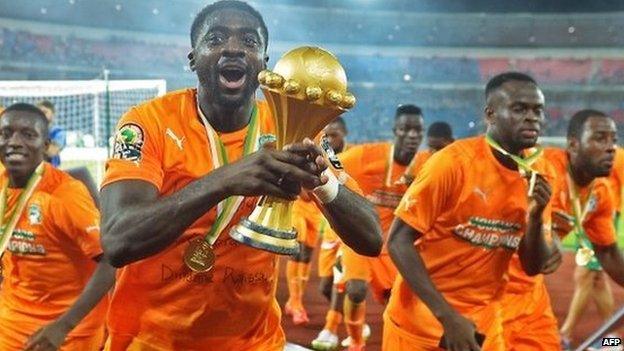 Ivory Coast's defender Kolo Toure raises the trophy as he celebrates after winning the 2015 African Cup of Nations