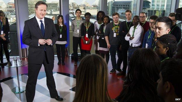 David Cameron standing in front of a group of young people