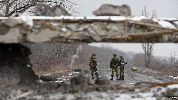 Pro-Russian separatist fighters stand on 9 February 2015 on a road near Uglegorsk, 6 kms southwest of Debaltseve.