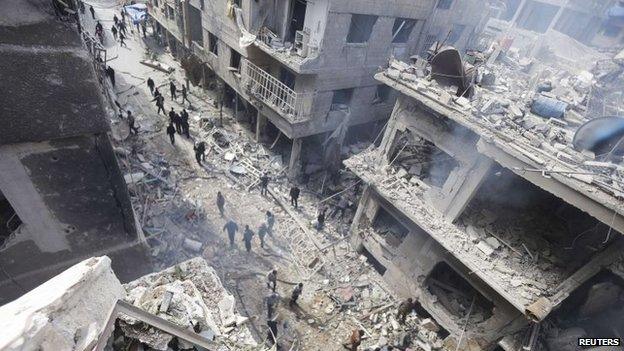 People inspect a site hit by what activists said were airstrikes by forces loyal to Syria's President Assad in Douma