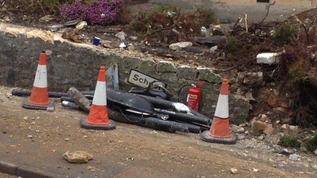 Collapsed garden wall at the scene of the crash