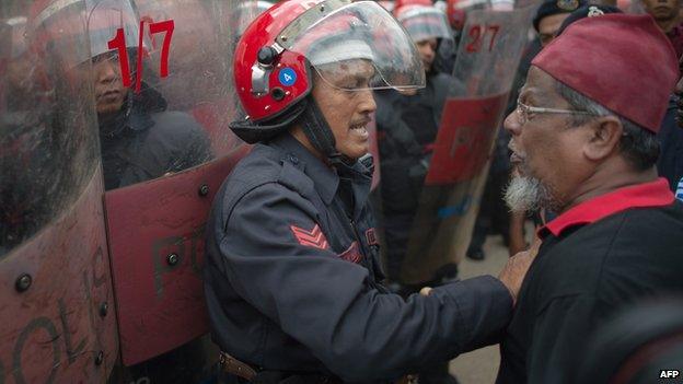 A Malaysian riot policeman (L) tries to control a supporter (R) of Malaysian opposition leader Anwar Ibrahim after Anwar's appeal on a sodomy conviction was rejected outside the federal court in Putrajaya, outside Kuala Lumpur on February 10, 2015.