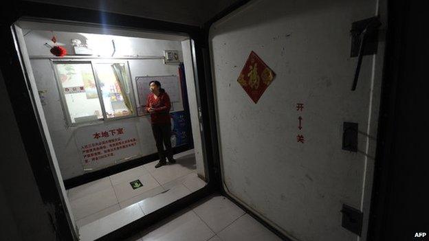 A resident standing at the entrance to underground housing inside an old civil defence shelter