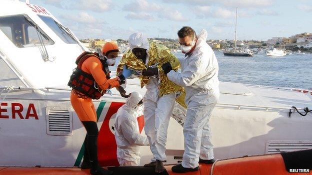 A migrant is helped as he arrives with others at the Lampedusa harbour - 11 February 2015