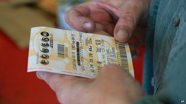 A man holds a Powerball ticket.