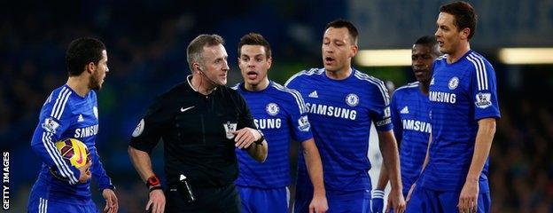 Chelsea's players surround referee Jon Moss