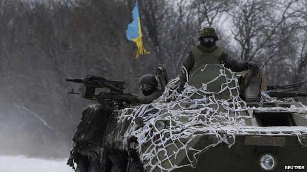 Members of the Ukrainian armed forces ride on an armoured personnel carrier (APC) near Debaltseve