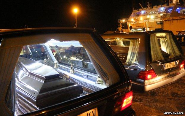 The coffins with the bodies of immigrants who died trying to reach the Italian coast arrive from Lampedusa on 11 February 2015 disembark in Porto Empedocle where they will be buried in cemeteries of the area.