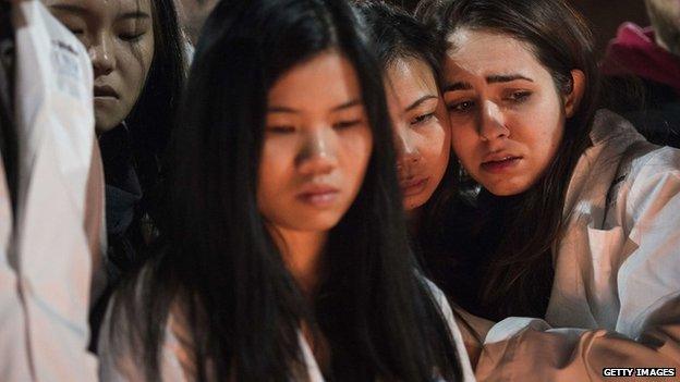 Dentistry students and others huddle together during a vigil at the University of North Carolina following the murders of three Muslim students on 11 February 2015 in Chapel Hill, North Carolina.