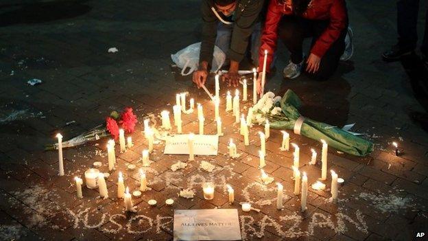 Anay Reddy and Mrinalini Ramanan light candles following a vigil for three people who were killed at a condominium near UNC-Chapel Hill, Chapel Hill,NC 11 February 2015