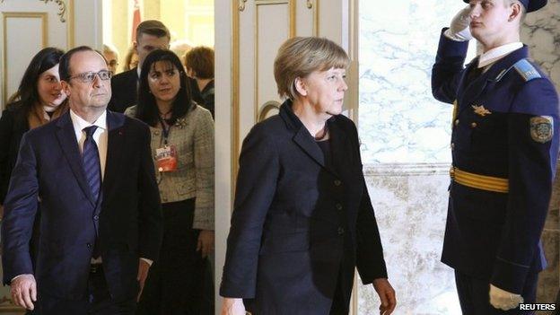 Germany"s Chancellor Angela Merkel (R) and France"s President Francois Hollande (L, front) walk past an honor guard as they take part in peace talks on resolving the Ukrainian crisis in Minsk, February 12, 2015