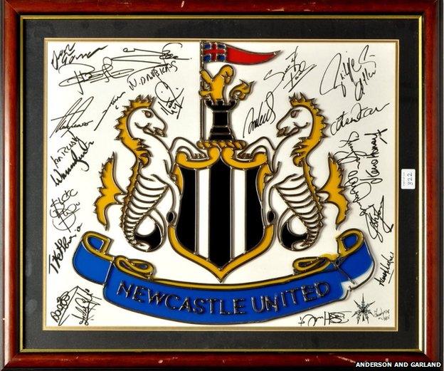 A Newcastle United crest signed by multiple players