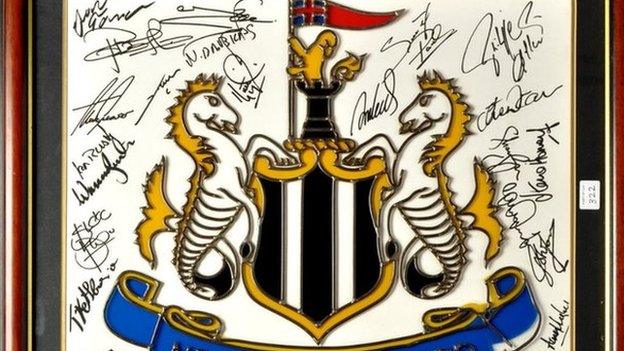 A Newcastle United crest signed by multiple players