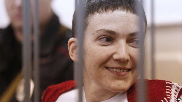 Ukrainian air force officer Nadezhda Savchenko smiles as she stands inside a defendant's cage during her hearing at the Basmanny district court in Moscow on 10 February 2015