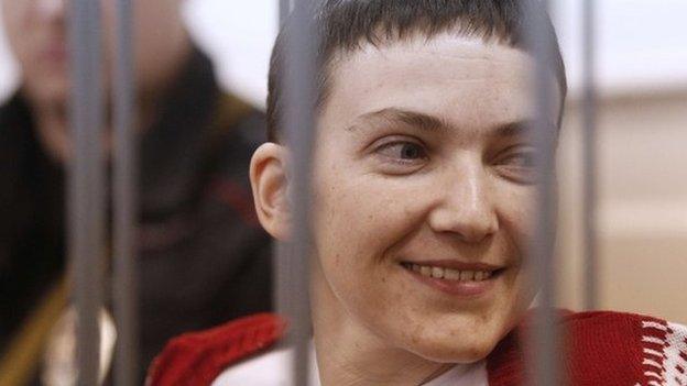 Ukrainian air force officer Nadezhda Savchenko smiles as she stands inside a defendant's cage during her hearing at the Basmanny district court in Moscow on 10 February 2015