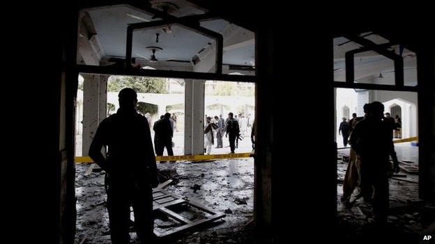 Members of the Pakistani security services stand at the scene of a suicide bomb blast targeting a Shia Mosque in Peshawar, Pakistan, 13 February 2015