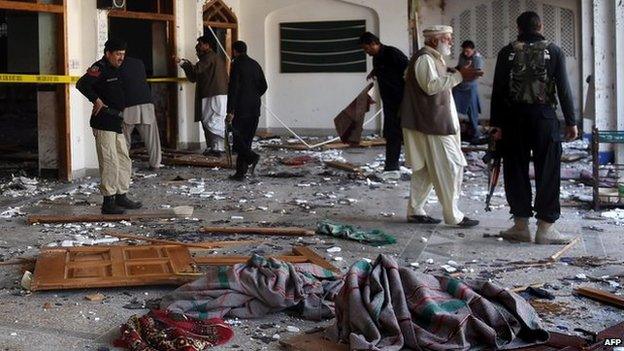 Pakistani security personnel inspect a Shiite Muslim mosque after an attack by Taliban militants in Peshawar on 13 February 2015.